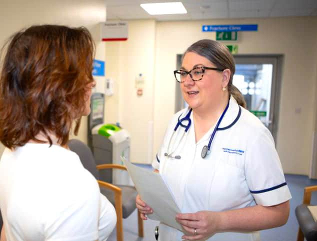 Two nurses having a chat in a hospital corridor