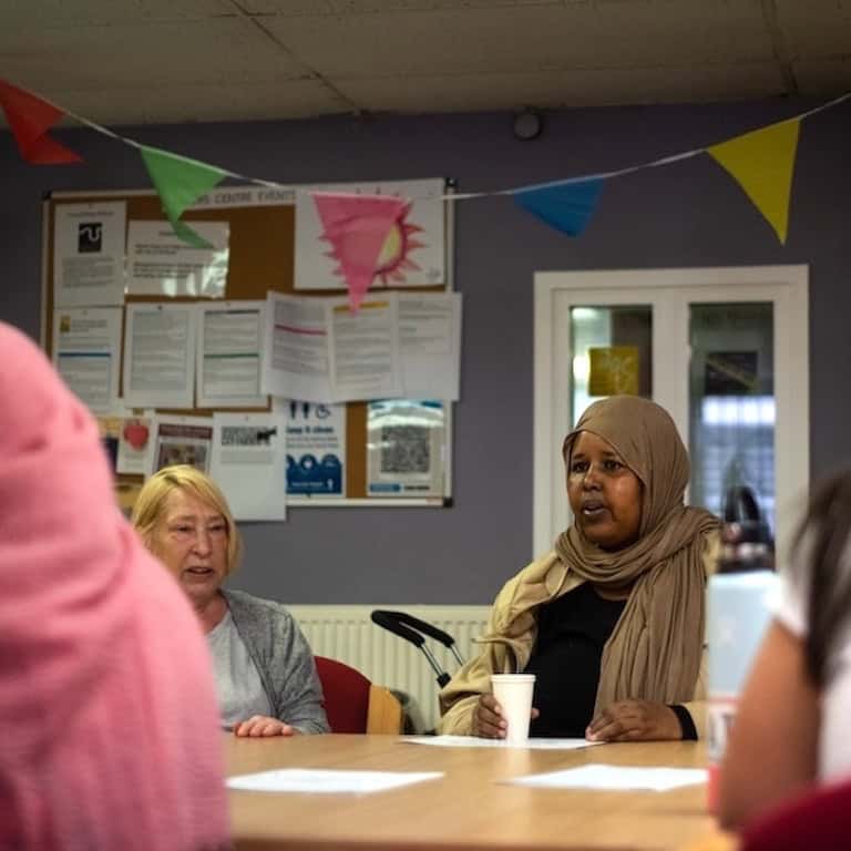 A group of people round a table having a discussion