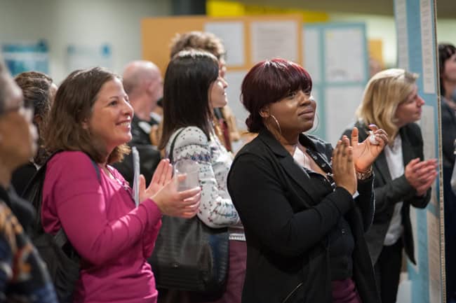 A group of people standing and applauding