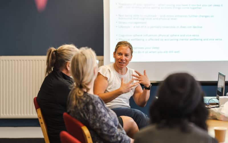 A group of women sit at a table having a discussion