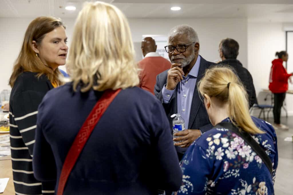 Four people stood in a group and in the midst of discussions.